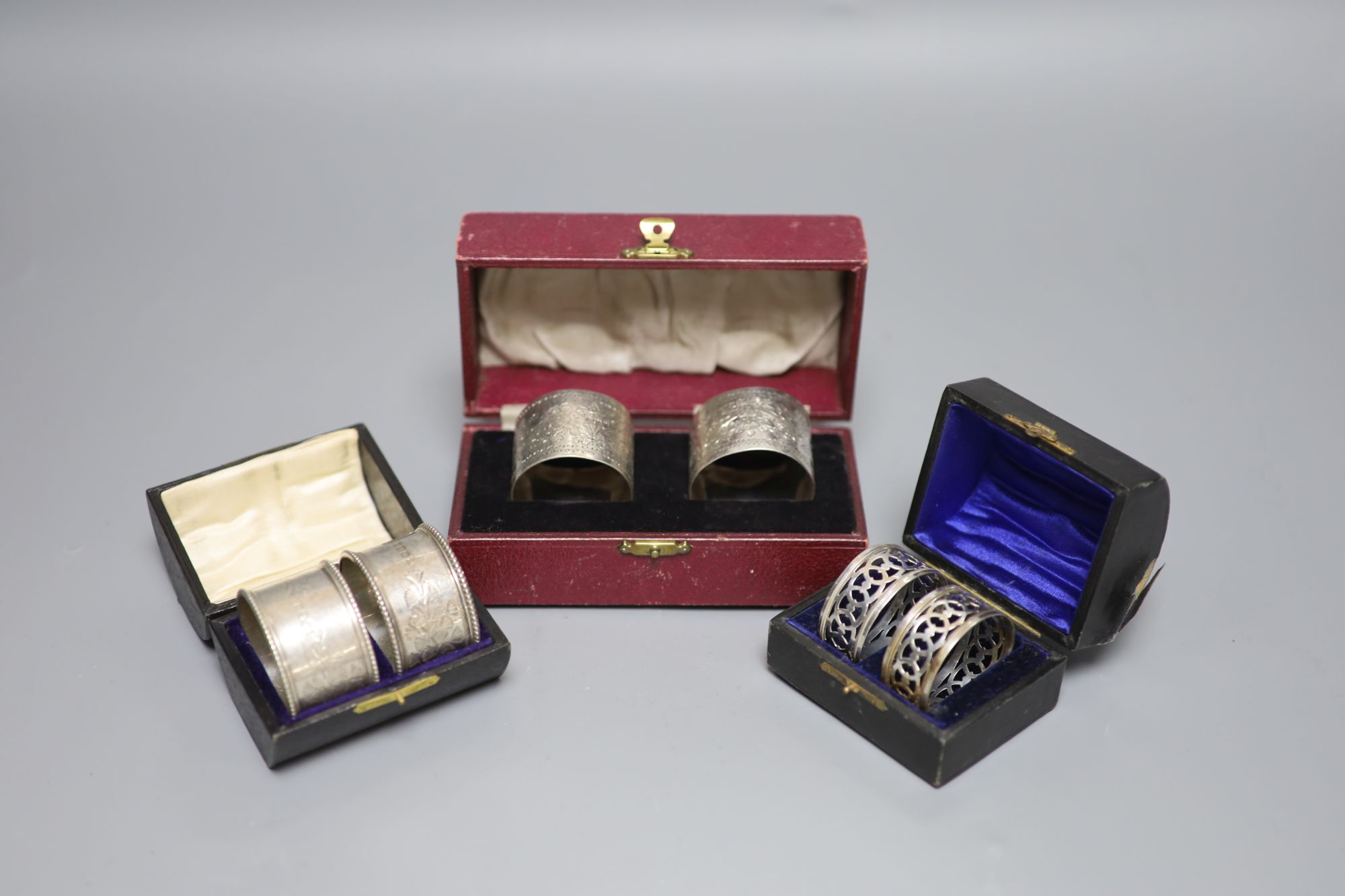 Three cased pairs of Edwardian and later silver napkin rings.